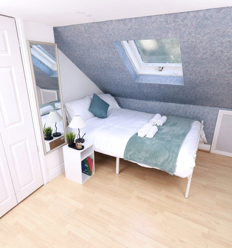 Attic bedroom with single bed, skylight window and wooden floor
