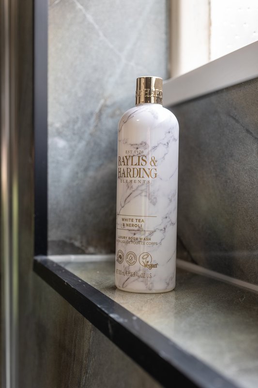 Bathroom windowsill with branded toiletry bottle and natural light from window