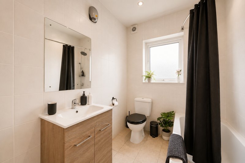 Modern bathroom with vanity, mirror, toilet, window and black shower curtain