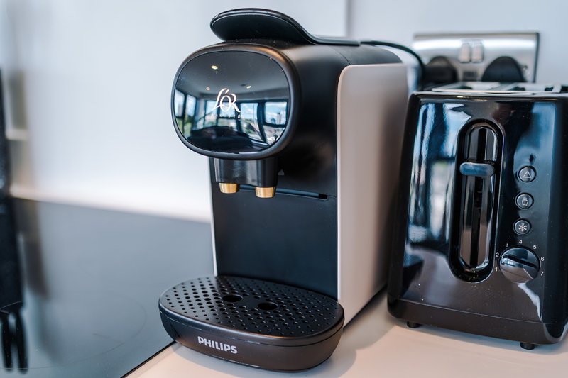 Kitchen counter with Philips coffee machine, black toaster, and other small appliances
