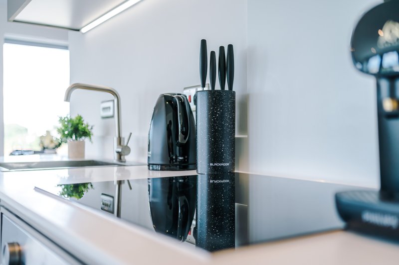 Modern kitchen countertop with kettle, knife block, and small appliances