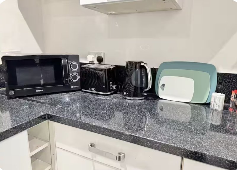 Modern kitchen counter with microwave, kettle, toaster and small appliances