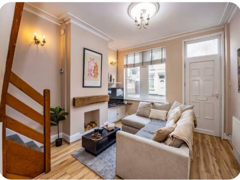 Bright living room with cream sofa, fireplace, wooden beams and large windows