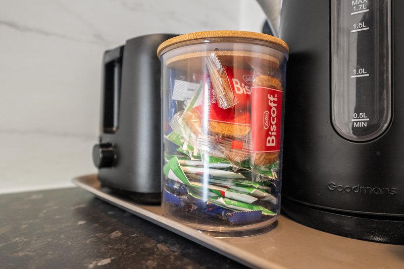 Kitchen counter with blender, food storage container, and black appliances