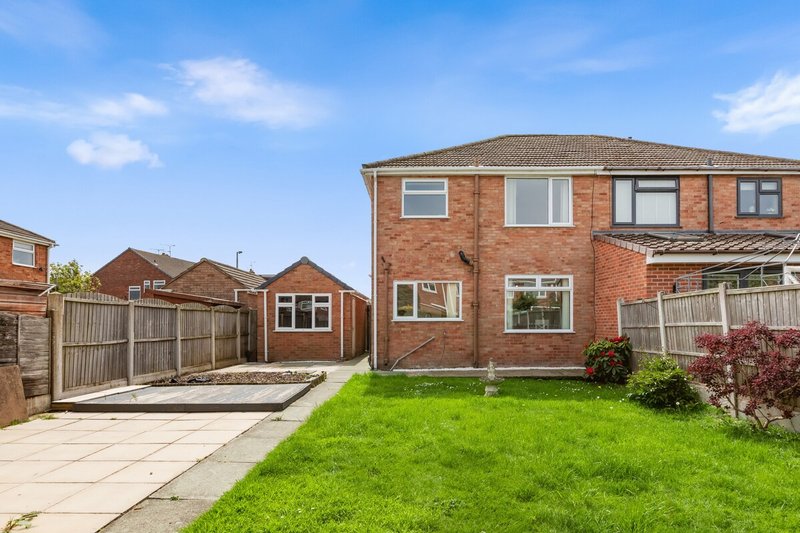 Brick semi-detached house with driveway, garden, and patio area