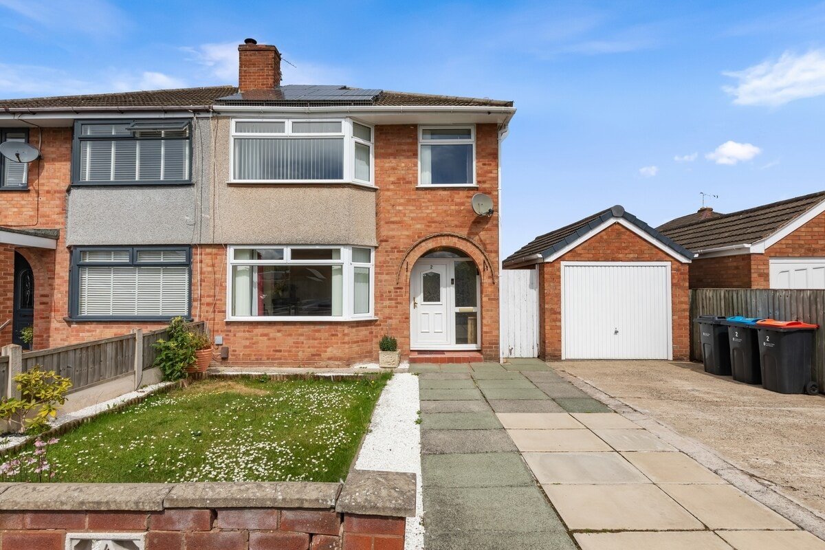 Brick semi-detached house with driveway, front garden, and white garage door