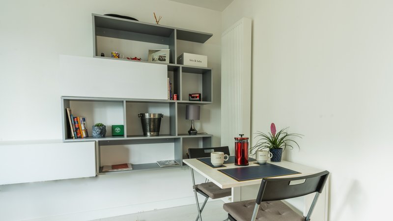 Minimalist home office with wall-mounted shelving, desk, chair and potted plant