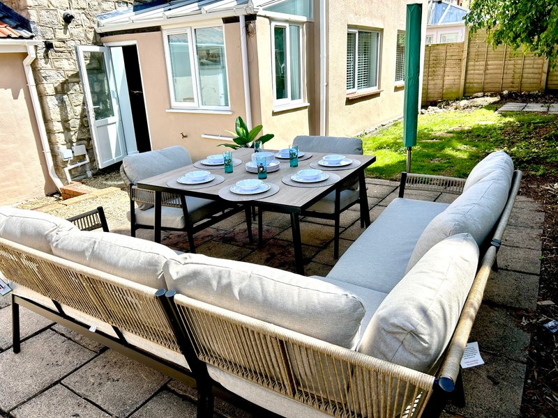 Garden patio with modern outdoor furniture, dining table, and seating area