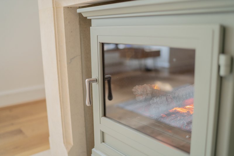 Close-up of white-framed window with metal handle and wooden floor visible