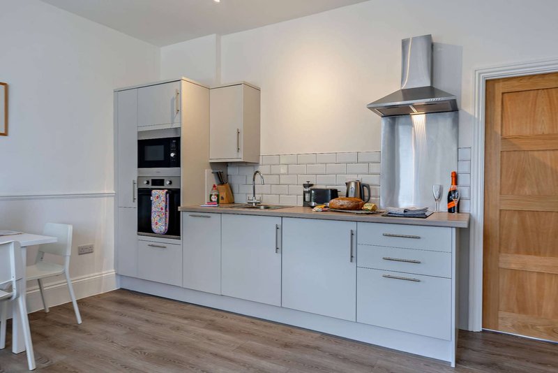 Modern kitchen with light blue cabinetry, stainless steel appliances, white subway tile backsplash
