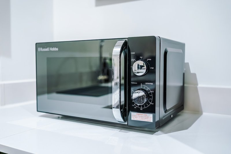 Black and silver microwave oven on white kitchen counter