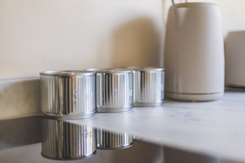 Marble countertop with metallic ribbed candles and ceramic vessels in soft light