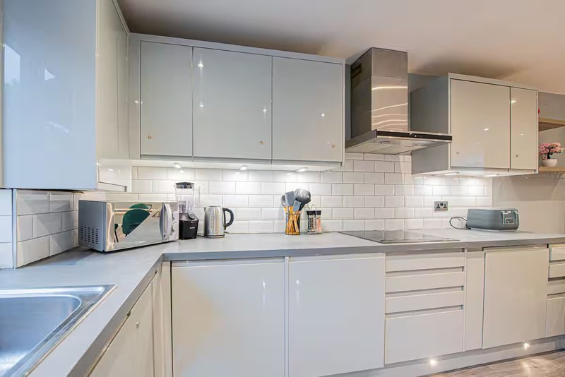 Modern kitchen with white cabinets, subway tile backsplash, stainless steel appliances and countertops