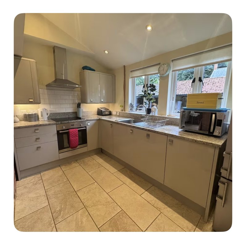 Modern kitchen with cream cabinetry, granite countertops, stainless steel appliances and tiled flooring