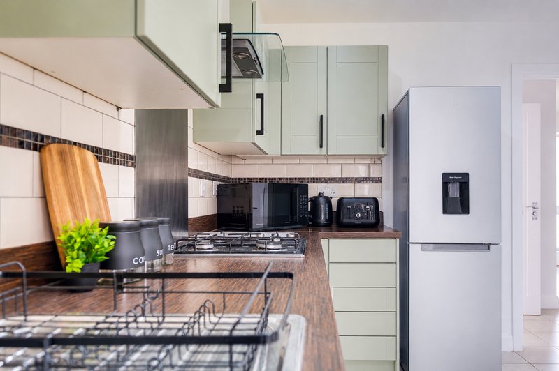 Modern kitchen with cream cabinetry, dark worktops, gas hob and stainless steel appliances