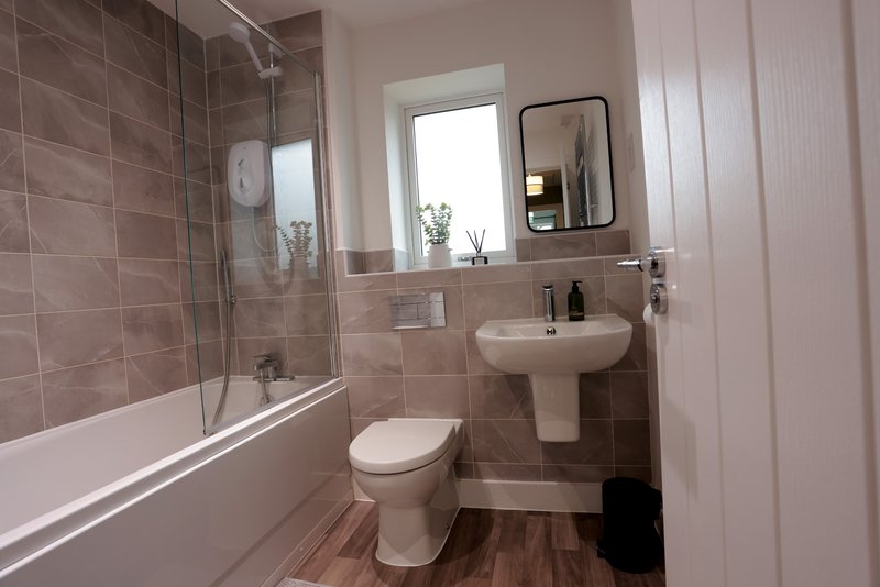Modern bathroom with bathtub, shower enclosure, pedestal sink, toilet and mirror