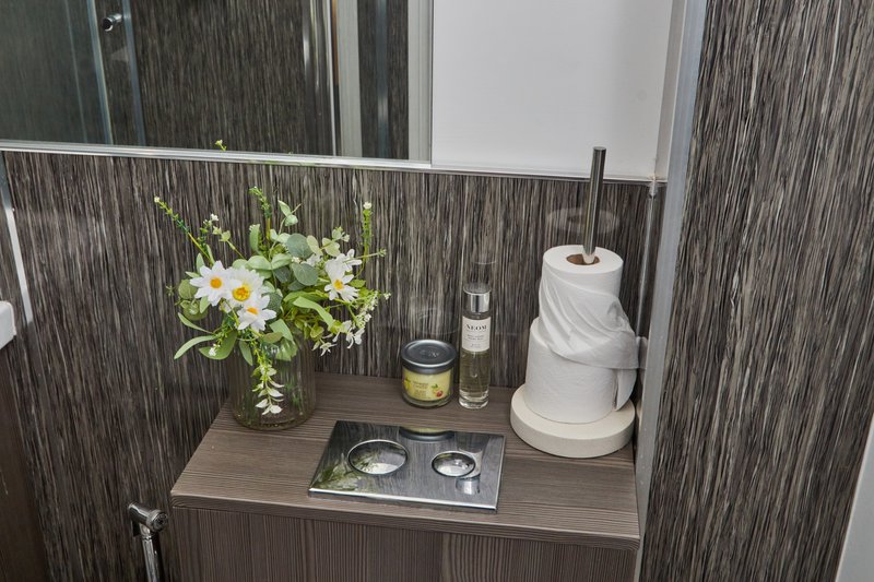 Bathroom counter with flower arrangement, toiletries, and paper towel holder