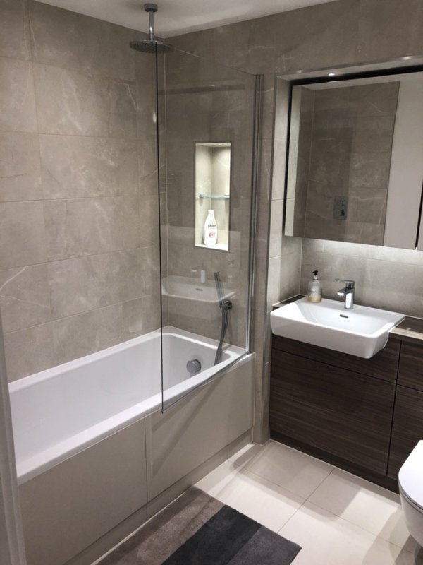 Modern bathroom with bathtub, glass shower enclosure, vanity sink and mirror