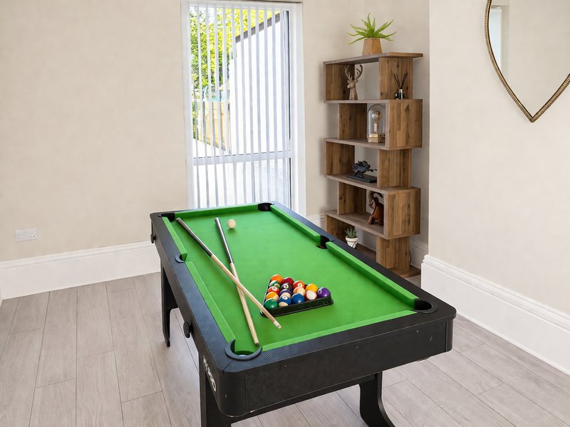 Games room with pool table, wooden shelving unit, mirror and glass door to garden