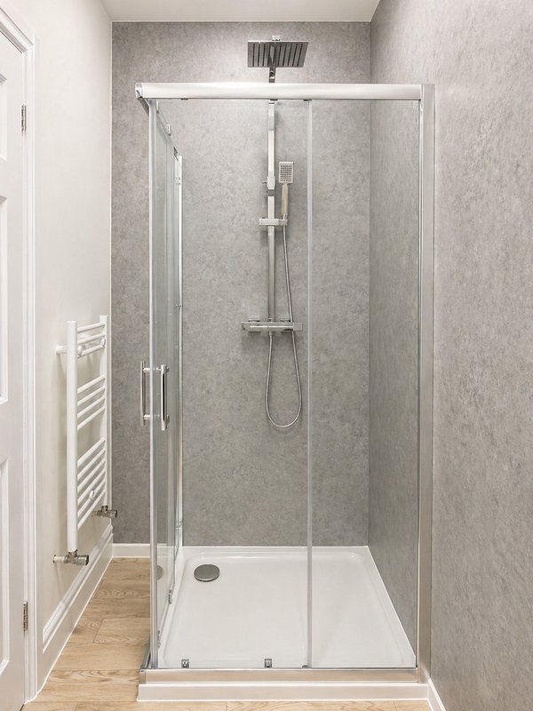 Modern bathroom with enclosed shower cubicle, rainfall showerhead and white towel rail