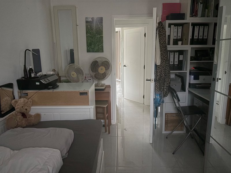 Bedroom with single bed, desk, shelving, fan, and white interior doors