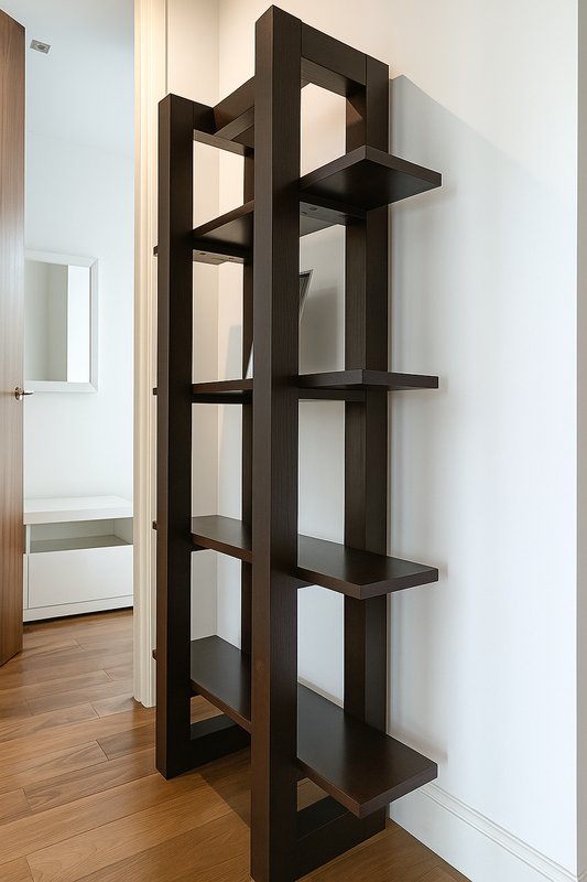 Modern black wooden shelving unit against white wall in bright hallway