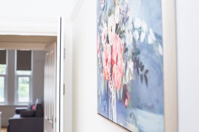 Modern hallway with framed abstract artwork on white wall and open doorway