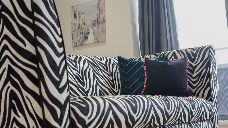 Modern living room with zebra-stripe patterned sofa and decorative cushions