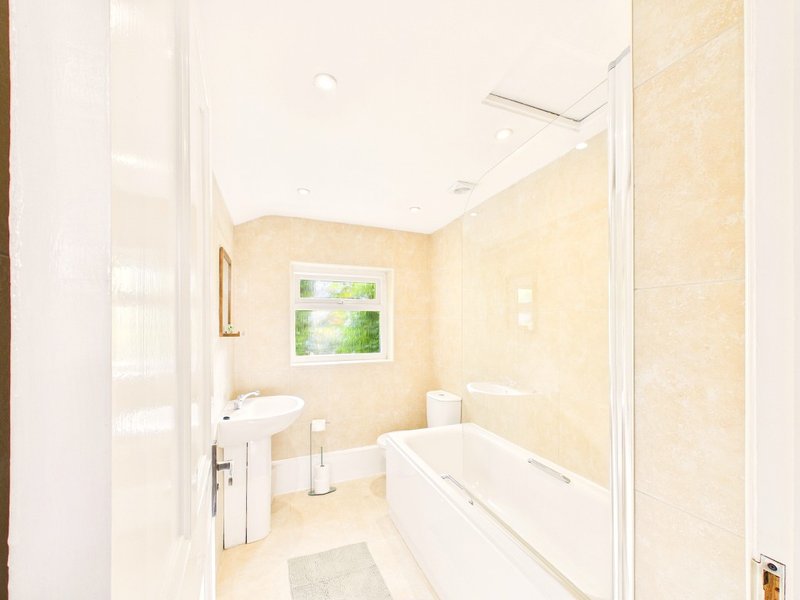 Modern bathroom with bathtub, shower enclosure, sink and cream-colored walls