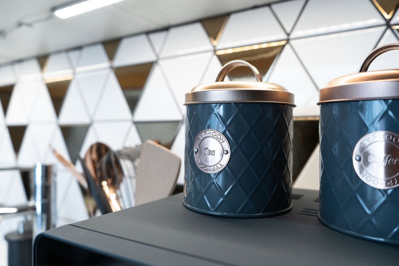 Kitchen counter with decorative storage containers, utensils and modern geometric wall decor