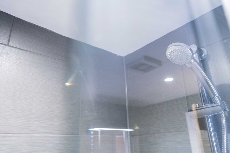 Modern bathroom shower enclosure with rainfall showerhead and glass walls