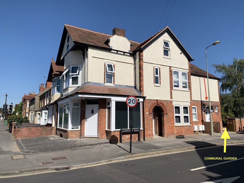 Period residential building with cream and brick facade, corner storefront conversion, street frontage