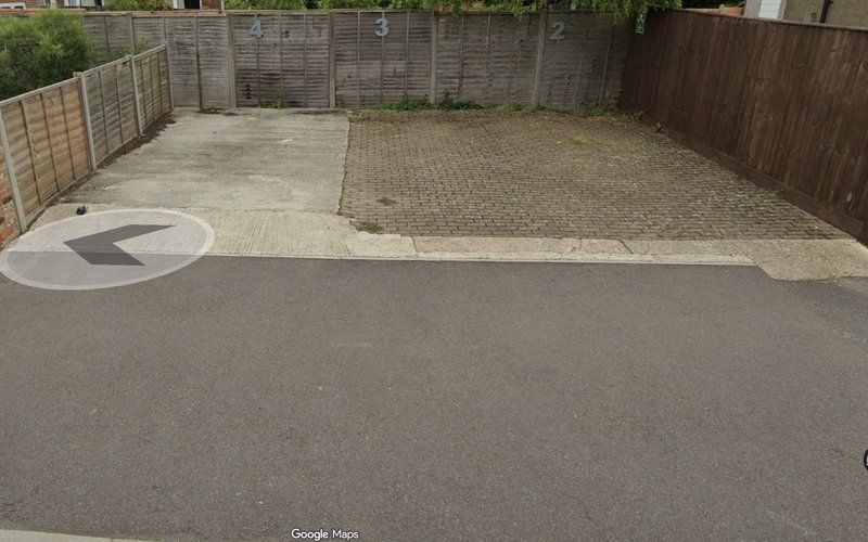 Driveway and paved garden area with wooden fencing and gate