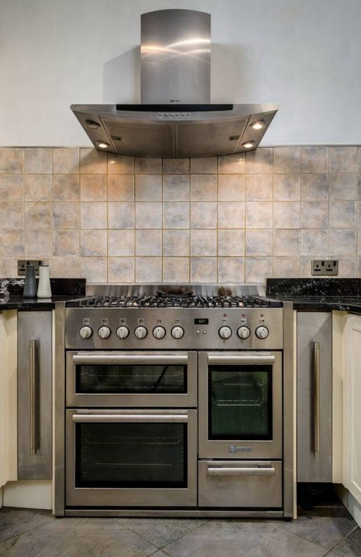 Modern kitchen with stainless steel dual oven range, matching extractor hood, and tiled backsplash