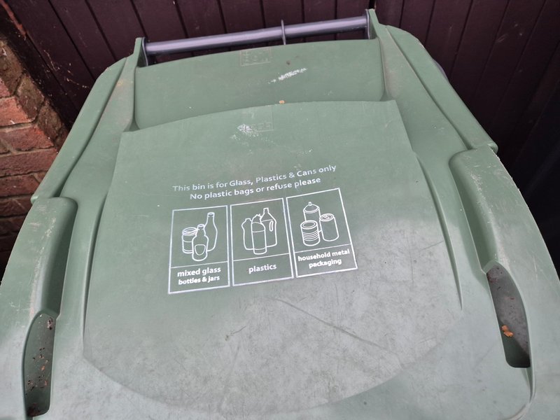 Green recycling bin with waste sorting instructions and pictograms
