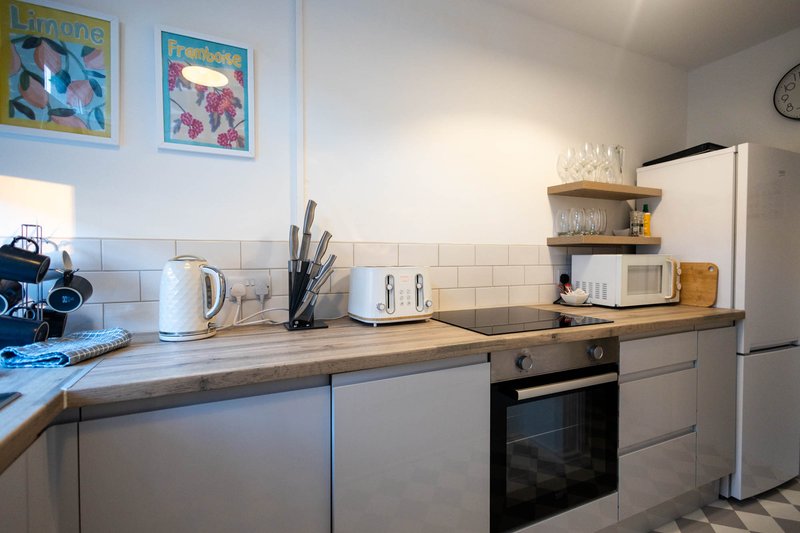 Modern kitchen with white cabinets, wooden countertop, stainless steel oven and fridge