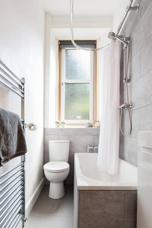 Modern bathroom with toilet, shower enclosure, heated towel rail and window