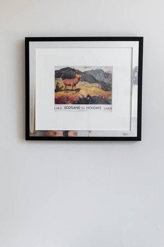 Framed wall art featuring Scottish Highland landscape with deer and decorative text