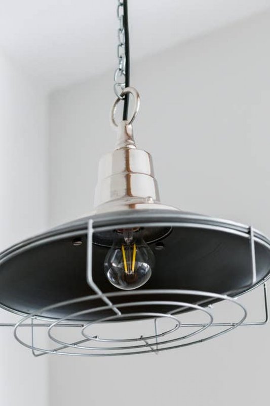 Modern pendant light fixture with black dome shade and chain suspension