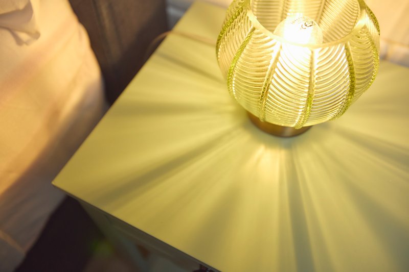 Close-up of decorative yellow pendant lamp casting warm light on surface