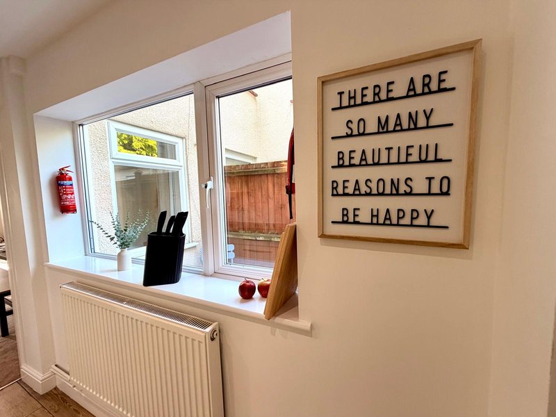 Kitchen with window, radiator, wooden sill and motivational wall sign