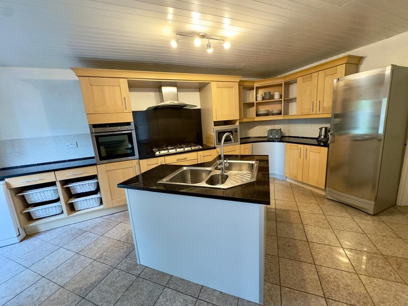 Modern kitchen with wooden cabinets, stainless steel appliances and central island with sink