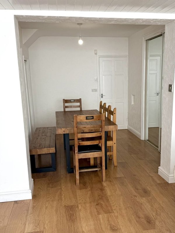 Dining area with wooden table, chairs, and bench on laminate flooring