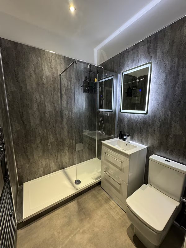 Modern bathroom with walk-in shower, vanity unit, illuminated mirrors and toilet