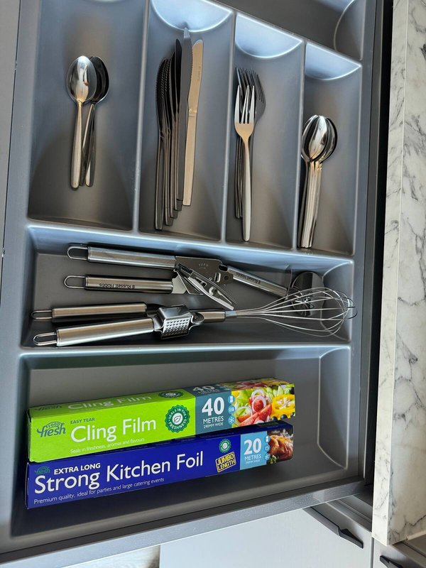 Kitchen drawer organizer with cutlery, utensils, and food storage wraps