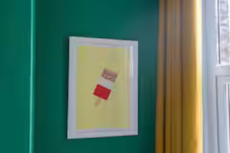Teal bedroom wall with framed abstract artwork and window with curtains