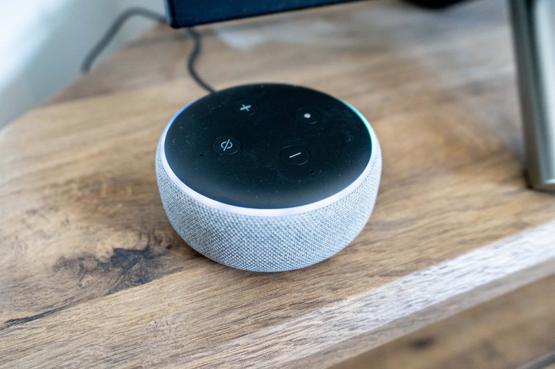 Smart speaker device on wooden table in furnished room
