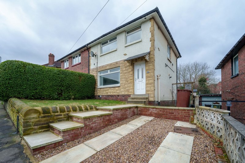 Semi-detached house with brick and rendered facade, front garden with raised beds and paving stones