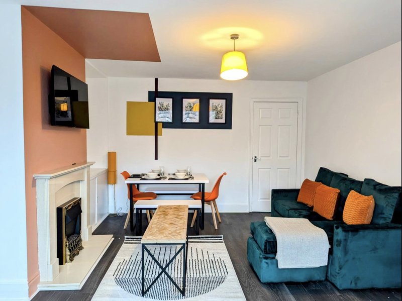 Open-plan living area with fireplace, dining table, sofa, and modern furnishings