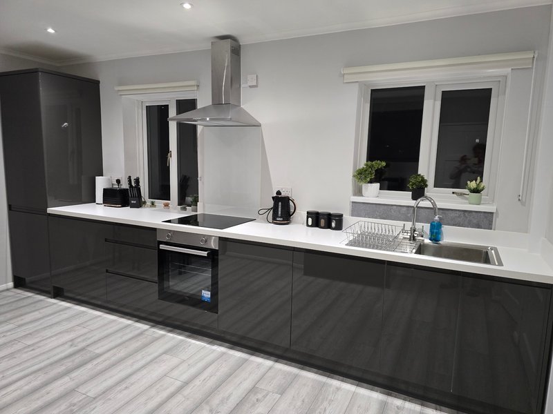 Modern black and white kitchen with island, stainless steel extractor hood and sink